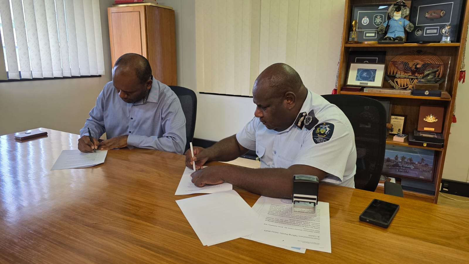 Right Acting RSIPF Commissioner with CAASI Director Mr. Brian Halisanu shake hands after the MoC signing.